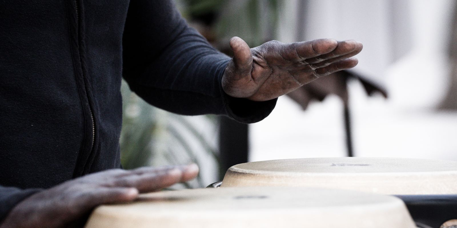 Close-up of hands playing a pair of conga drums
