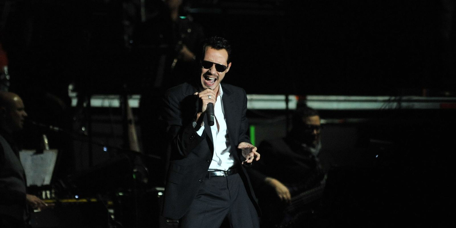 Marc Anthony singing into a microphone during a concert