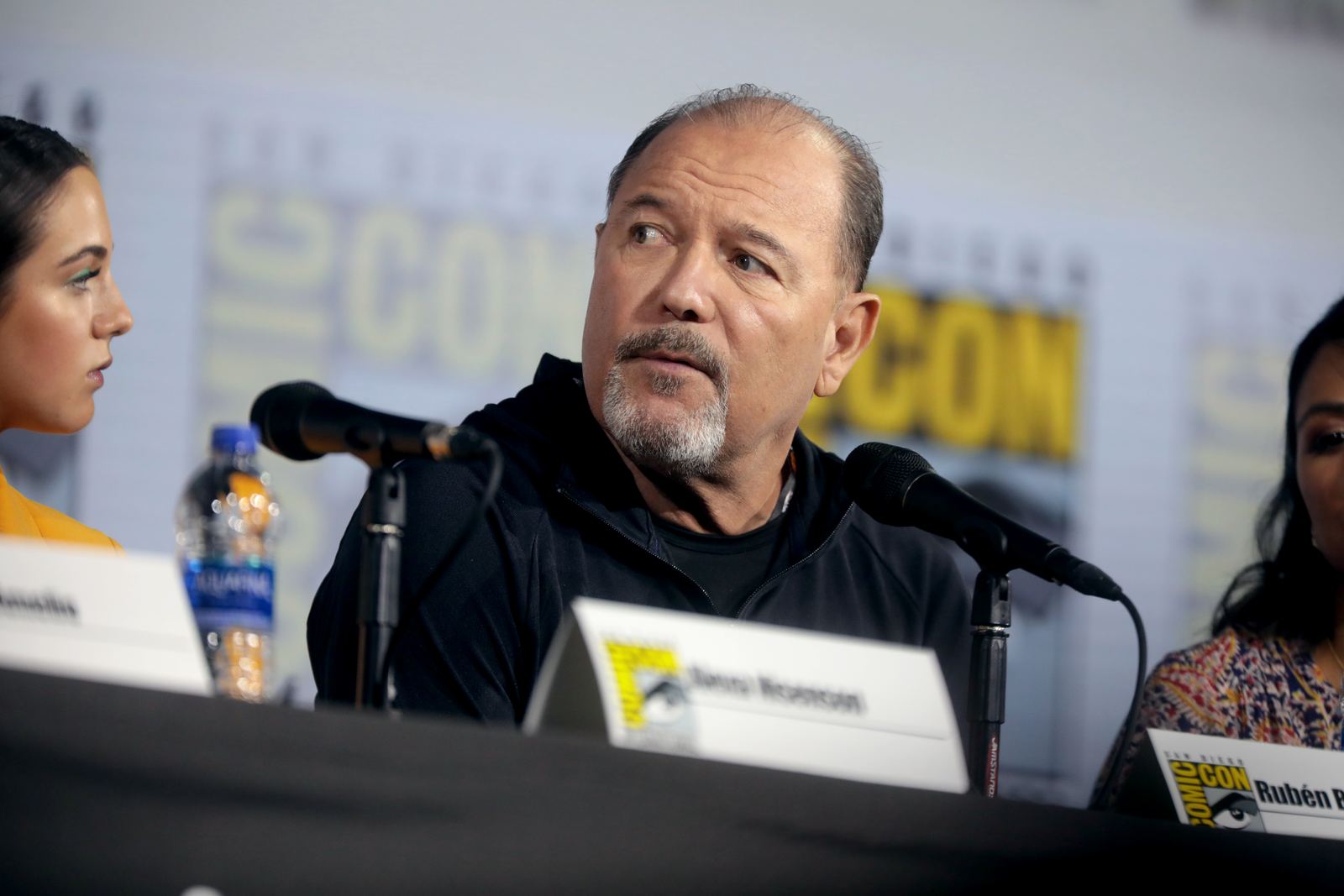 Rubén Blades speaks into a microphone at a panel discussion