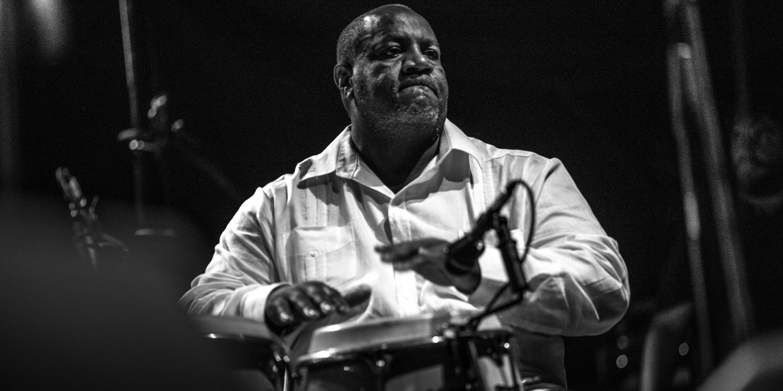 A Latin percussionist playing congas on stage at a jazz festival in Punta del Este