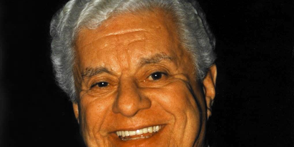 Tito Puente smiling in a suit and tie